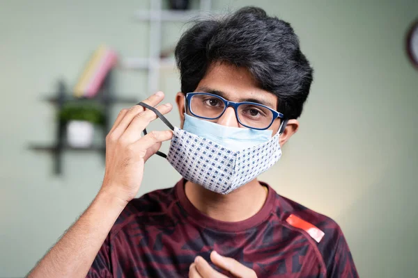 Portrait Young man wearing double or two face mask to protect from coronavirus or covid-19 outbreak - concept of safety, healthcare, medical and hygiene