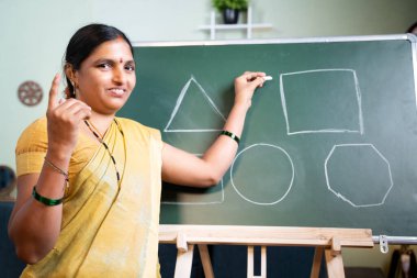 Hintli bir kadın çevrimiçi derste kameraya bakarak açıklama yapmakla meşgul - e-öğretim kavramı, uzaktan öğrenme, koronavirüs salgını sırasında sanal eğitim.