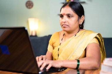 Ciddi, tembel bir kadın, evden çalışırken laoptop üzerinde çalışmakla meşgul - Coronavirus covid-19 salgınından dolayı yeni normal teknolojik yaşam tarzı kavramı