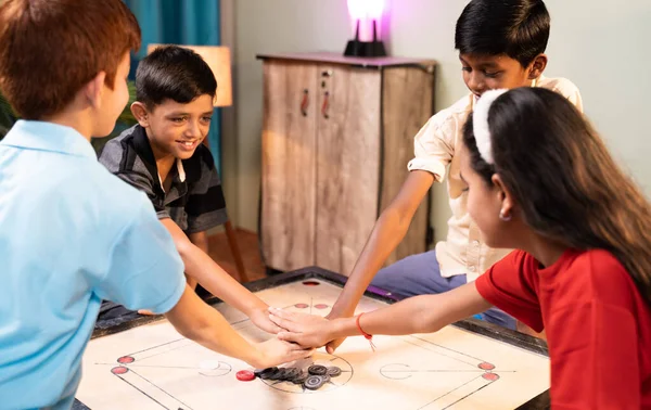 Concéntrate en Carrom Coins, un grupo de niños que deciden jugar al carrom por parejas aplaudiendo o dando la vuelta a la mesa de carrom en casa - Concepto de estilo de vida de vacaciones infantiles y vacaciones de verano — Foto de Stock