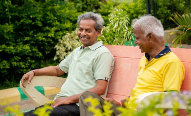 Yaşlı rahatlama, dostluk ve bağ kurma kavramını hatırlayarak parkta iyi vakit geçiren mutlu kıdemli arkadaşlar.