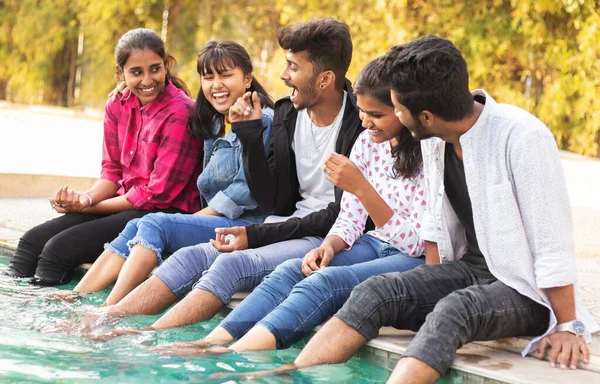 Focus on middle boy, Group of young millenials having fun and enjoying some good time near swimming pool - Concept of friendship, bonding and togetherness.