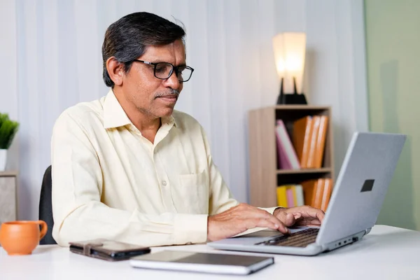 Zakenman lacht tijdens het werken of chatten op laptop op kantoor - concept van het gebruik van technologie, communicatie en internet — Stockfoto