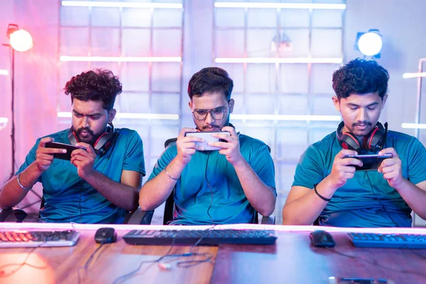 Vista frontal da equipe de jovens jogadores profissionais que jogam seriamente de videogame ao vivo no celular no torneio de esports. — Fotografia de Stock