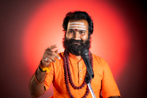 Beard Indian god man or holy guru with rudraksha mala preaching holy vedas - concept of religious teachings by monks at temples.