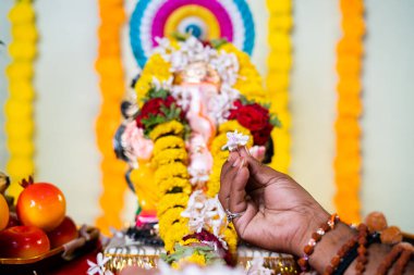 Kutsal guru 'ya ya da papazın ellerine odaklanın. Lord Vignesh' e çiçek ya da Ganesh 'e günlük azizlik ayinleri sırasında çiçek sunun. İnanç ve Hint kültürü kavramı..