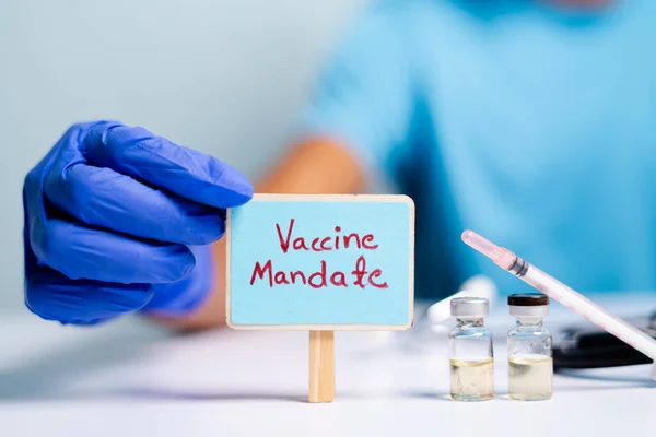 Coronavirus ya da covid-19 aşısı konsepti, aşı aşıları ve şırıngaların yanına pano yerleştirerek doktor elleriyle eldivenleri göstermek.