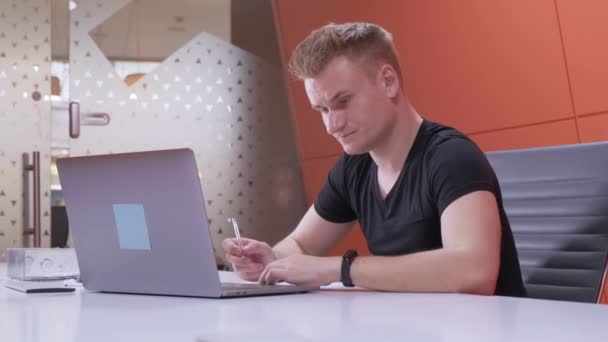 Joven Europeo Trabaja Tarde Utiliza Una Computadora Portátil Toma Notas — Vídeos de Stock