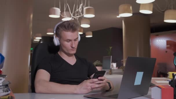 ハッピービジネスマンは職場で音楽を聴くヘッドフォンを着用する — ストック動画
