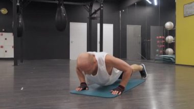 Spor salonunda şınav çeken bir adamın portresi.
