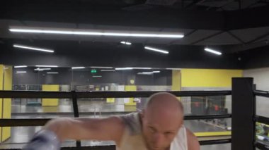Profesyonel, kaslı bir adamın sinematik çekimi ringde gölge boksu antrenmanı yapıyor..