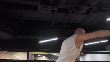 Boksör eğitimi, düşük ışık spor salonunda, karanlık arka planda. Ringde boksör eğitimi. Profesyonel bir delikanlının boks ringinde ağır çekim çekimleri.