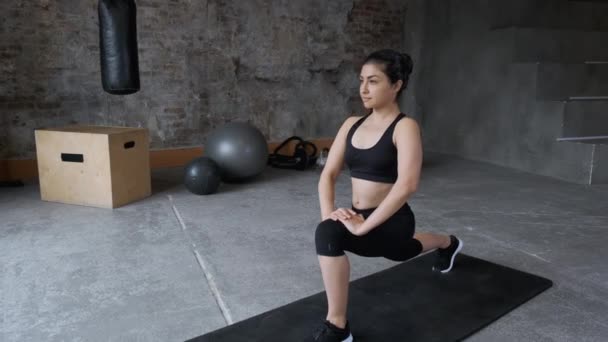 穿着黑色上衣和腿的年轻印度妇女做腿伸展运动 在健身房做运动 — 图库视频影像