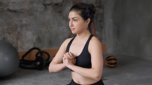 一名身穿黑色上衣的印度年轻女子的特写镜头和一名做腿伸展运动 在健身房做运动的腿 — 图库视频影像
