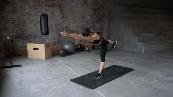 年轻的印度女子晨练平衡运动和伸展运动瑜伽 黑色运动服腿和上衣 明亮的健身房 — 图库视频影像