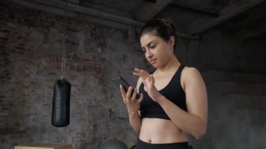 fitness Hindistanlı bayan sporcu akıllı telefon görüntülü sohbet kullanarak egzersiz paylaşımı spor salonundaki mobil iletişim sporcusunun keyfini çıkarıyor
