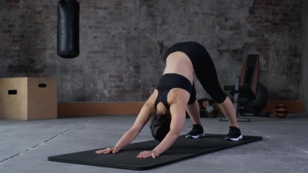 体操俱乐部的女运动员在健身垫上进行伸展训练 柔韧的健身女子伸展肌肉在运动俱乐部的垫子上劈开 — 图库视频影像