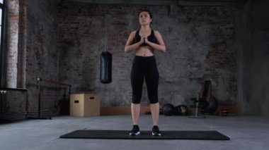 Genç Hintli fitness kadını spor salonunda çömeliyor..