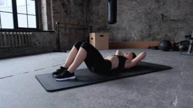 Spor giyimli atletik Hintli kadın abdominalleri pompalıyor. Sportif formda bir kadın spor salonunda karın egzersizleri yapıyor. Spor, fitness, antrenman, egzersiz ve sağlık konsepti