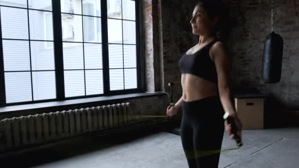 身穿运动服 身穿黑色上衣和紧身衣的印度女青年在健身房接受跳绳训练后跳了起来 — 图库视频影像