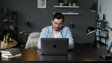 İşadamı odaklı girişimci dizüstü bilgisayarla araştırma yapıyor. Bilgisayarı kullanan genç profesyonel bir erkek ofis masasında oturuyor. Modern teknoloji not defteri üzerinde çalışan meşgul bir işçi..