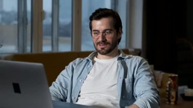 A young Man Discusses an online Project With a Colleague, Two Managers Work at Home, Use A laptop Computer