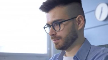 Ciddi düşünceli bir iş adamı dizüstü bilgisayarla çalışırken notlar alıyor. Avrupalı genç bir erkek işadamı evdeki ofiste dizüstü bilgisayarda çalışıyor.