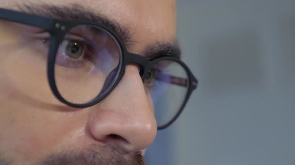 自宅でオンラインで働くコンピュータモニタ画面のメガネ反射を持つ男ビジネスマンのクローズアップ — ストック動画