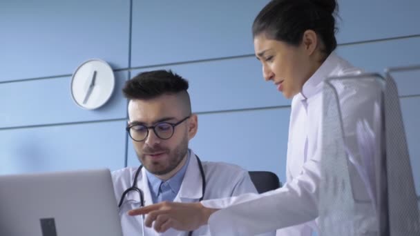医疗队两名年长的男医生和年轻的女医生穿着白衣交谈 使用数码平板电脑 2名医院工作人员握手 医学界的合作伙伴关系 医疗保健技术 — 图库视频影像