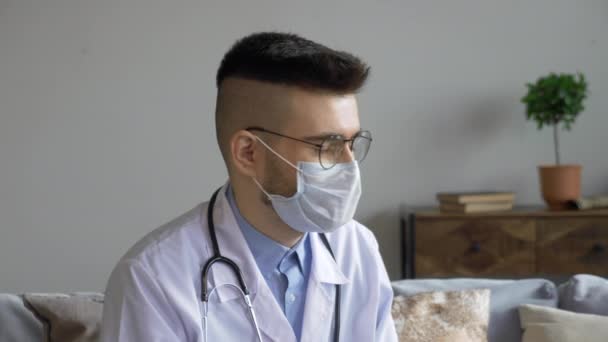 Close Jovem Médico Homem Com Óculos Uma Máscara Olha Para — Vídeo de Stock