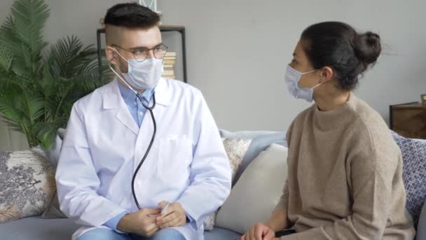 家庭訪問中に女性の血圧をチェックする男性医療従事者は — ストック動画