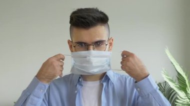 Bir Salgın sırasında Parlak Oda 'da Virüs Maskesi Takan Gözlüklü Genç Avrupalı Bir Adamın Portresi