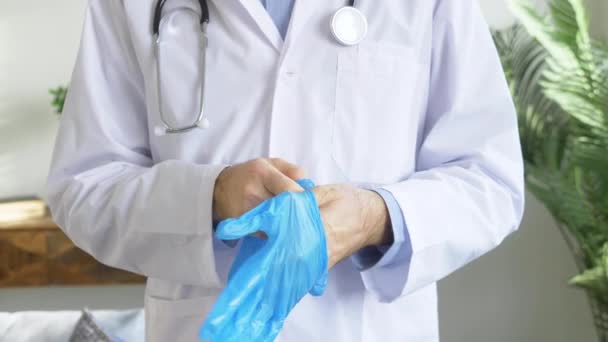 Ένας Γιατρός Ένα Λευκό Παλτό Βάζει Ελαστικά Γάντια Κατά Του — Αρχείο Βίντεο
