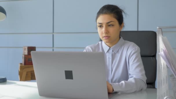 若いインド人女性フリーランスは コンピュータのラップトップでオンラインプロジェクトで働いています プログラマーは コードを書き 明るい部屋で自宅のオフィスで管理を行います — ストック動画