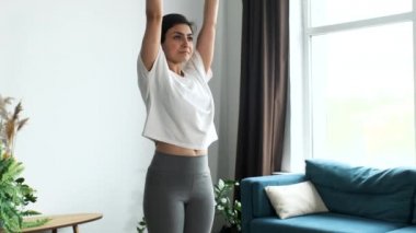 Yoga yapan genç Hintli kadın, sabah meditasyon yapıyor. Evde, parlak bir odada.