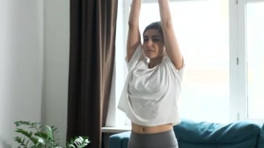 Genç Hintli Kadın Yoga Yapıyor, Sabah Meditasyon Yapıyor. Evde, parlak bir odada.