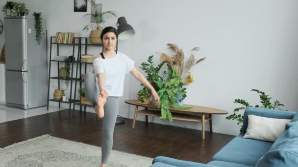 インドの女性は午前中にストレッチ 明るい部屋の自宅に位置しています バランスのために一本足で運動をする — ストック動画