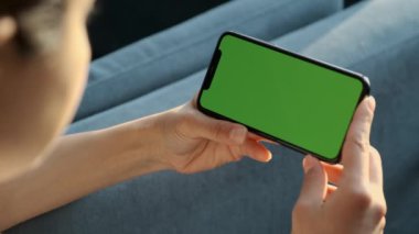 El kamerası: Esmer Kadın 'ın Krom Anahtar Tutan Yeşil Ekran Telefonu Dokunmadan ve Çalkalamadan İzleme İçeriği. Kız Cep Telefonu Kullanıyor, İnternet Taranıyor, İçerik İzleniyor