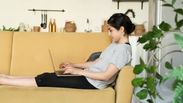 Woman Using Laptop Home Girl Lying Yellow Sofa Bright Room — Stock video