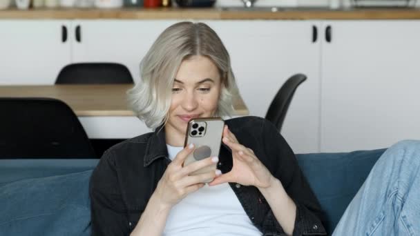 Young Caucasian Attractive Blonde Woman Looks Screen Texting Message Smartphone — Stock Video