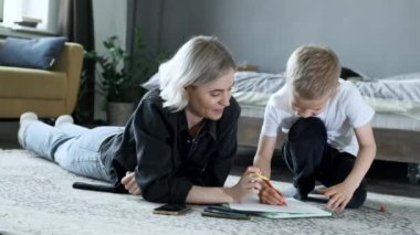 Orta ölçekli anne ve çocuğu sihirli kalemlerle birlikte yere çizmişler.