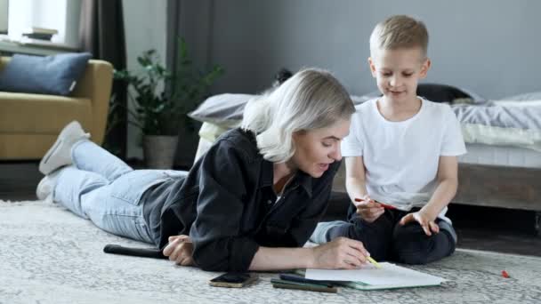 Ung Mor Och Ett Pojkbarn Ligger Golvet Och Ritar Med — Stockvideo