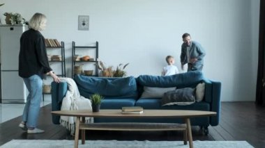 Happy family having fun time at home. A Young Family Father Mother and Little Son Are Having Fun At Home In A Bright Room