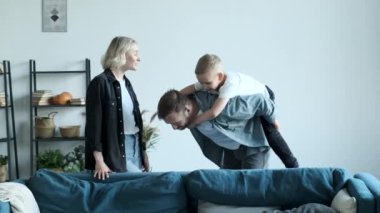 A Young Family Father Mother and Little Son Are Having Fun At Home In A Bright Room