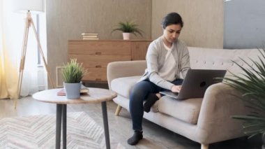 Evdeki kanepede oturan, dizüstü bilgisayar kullanan, internetten video izleyen, arkadaşlarıyla sohbet eden, blog okuyan, fotokopi çeken güzel bir bayan. Covid-19 salgını sırasında yaşam tarzı