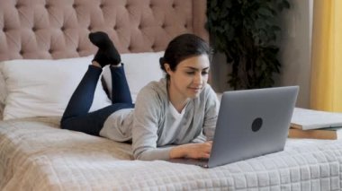 Genç Hintli Düşünceli Bir Kadın Klavyede Yazıyor, Bilgisayarda çalışıyor, Parlak Bir Odada Yatakta Yatıyor