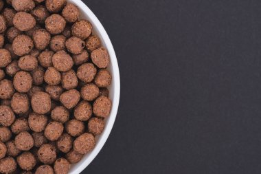 Beyaz cam kase çikolatalı mısır topu. Koyu gri bir arka planda izole edilmiş. Üst görünüm kapat