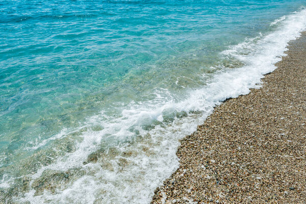 Pebble coast and waves in Antalia, Turkey. Konyaalti beach.