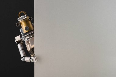 Siyah ve gri boş bir panonun köşesine bakan bir steampunk robotun portresi