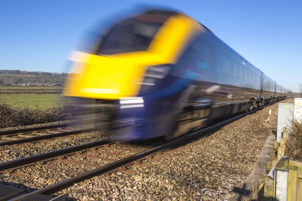 Chiuda in su del treno che accelera attraverso la campagna inglese sulla brillante — Foto Stock